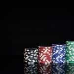 Vier stapels casino chips, gerangschikt van kleinste tot grootste en gerangschikt op kleuren.