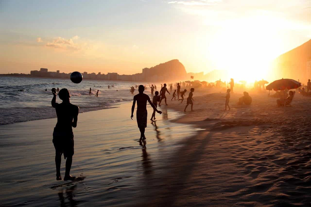 Jonge mensen op een strand in Rio de Janiero tijdens de zonsondergang.