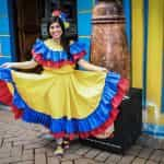 Colombiaanse vrouw het glimlachen, gekleed in typisch kostuum met de kleuren van de vlag.